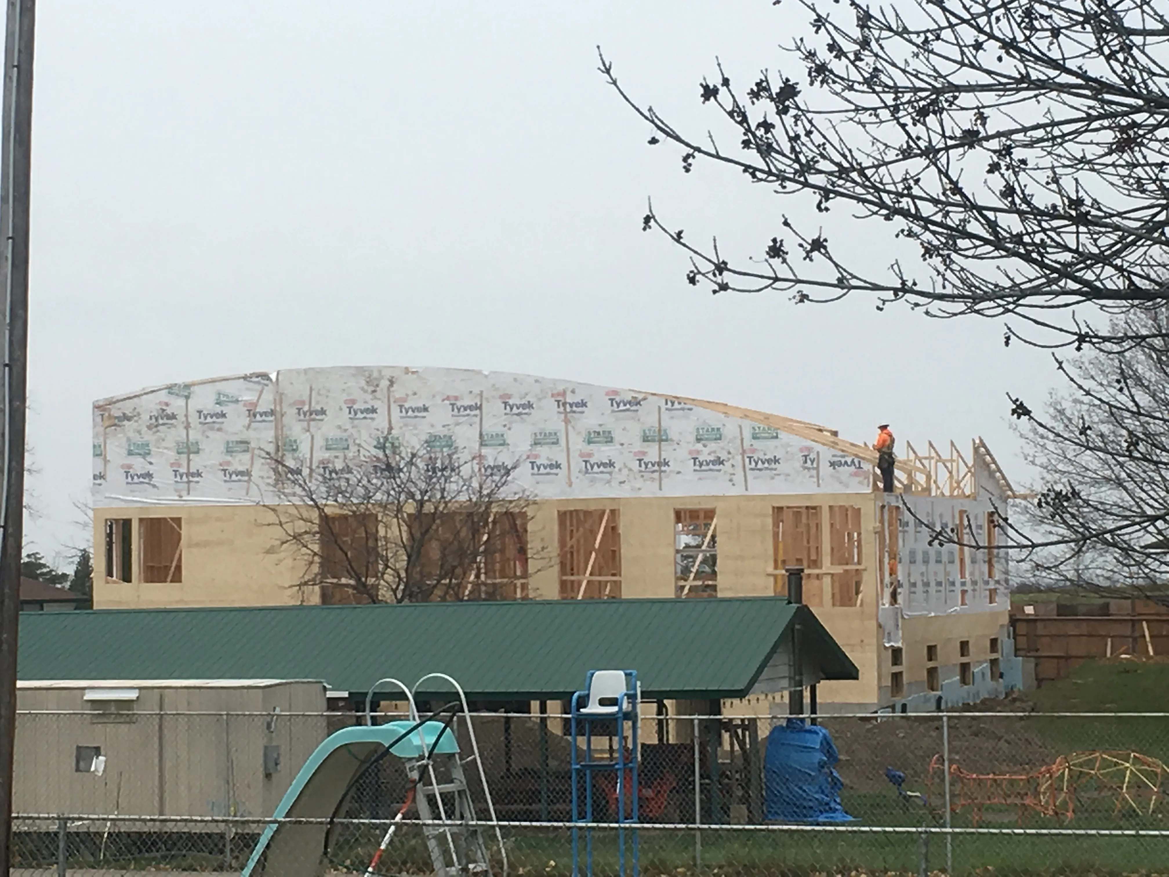 Large building under construction wrapped in Stark Lumber branded housewrap