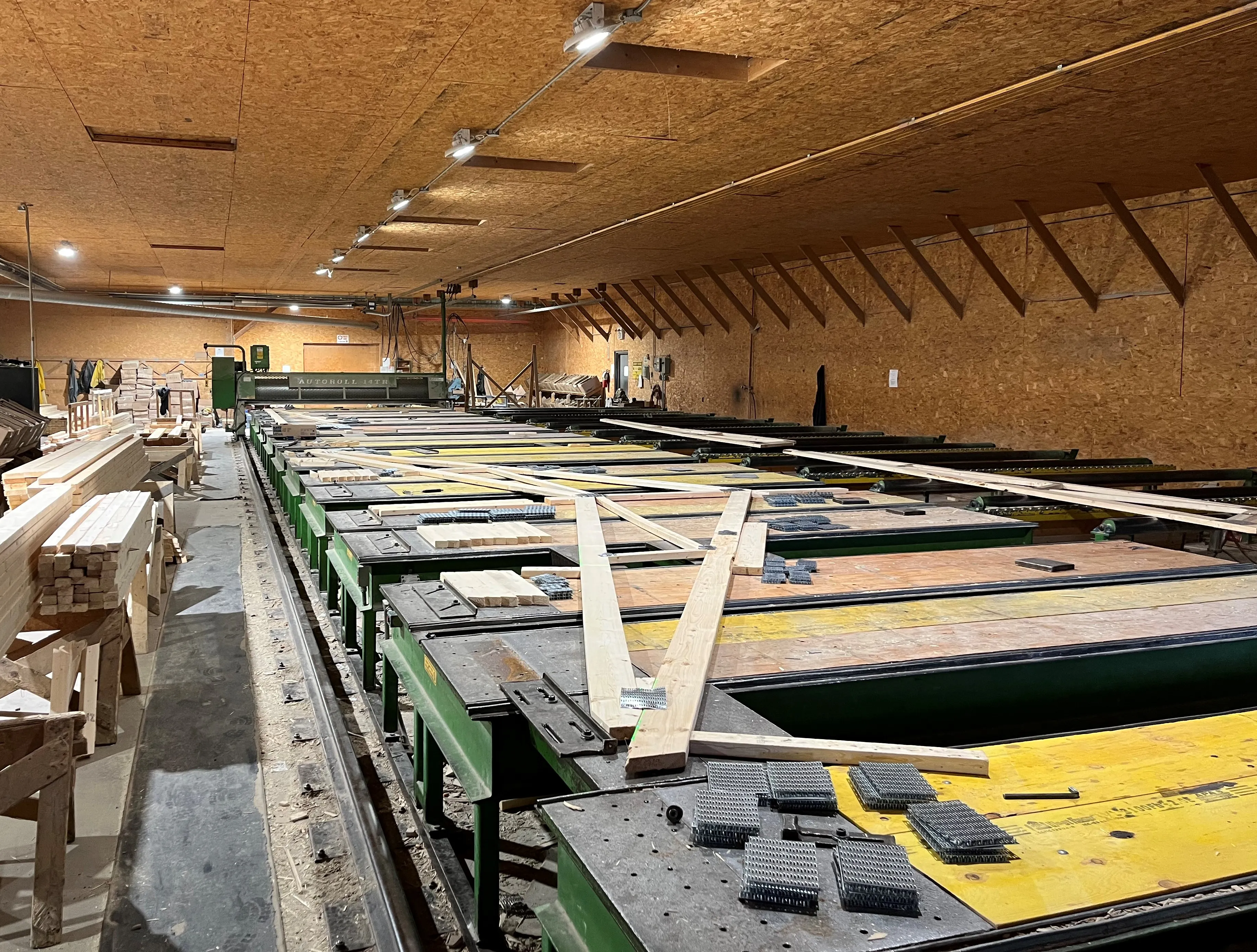 Roof truss components laid out on the assembly tables inside Stark's truss shop