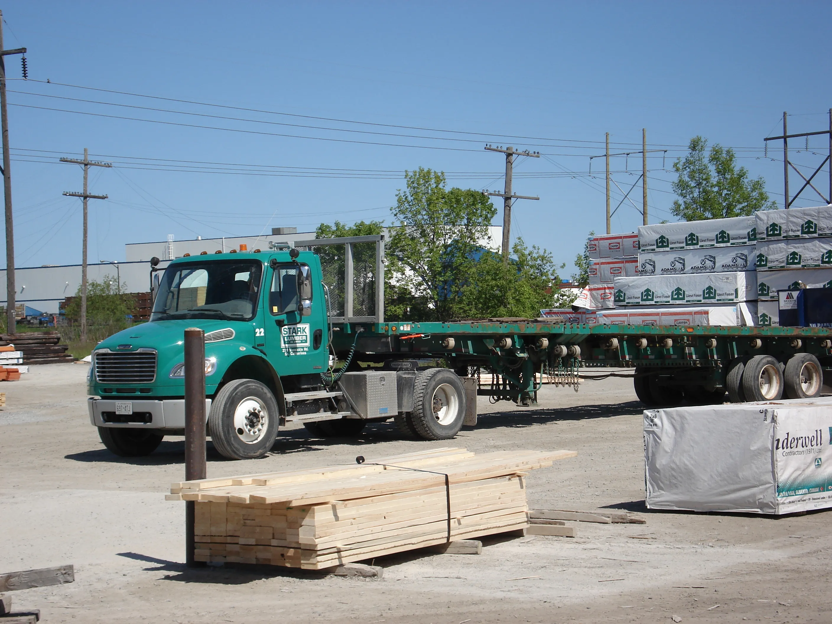 Stark Lumber flatbed truck in the yard among stacks of lumber